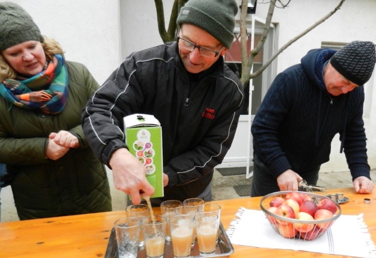 Three people sampling apple juice